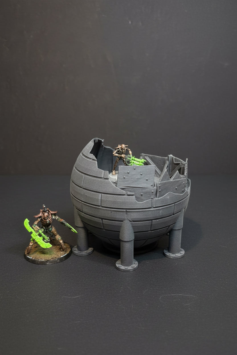 Sci-fi ruined guard tower terrain with miniature for scale on tabletop battlefield